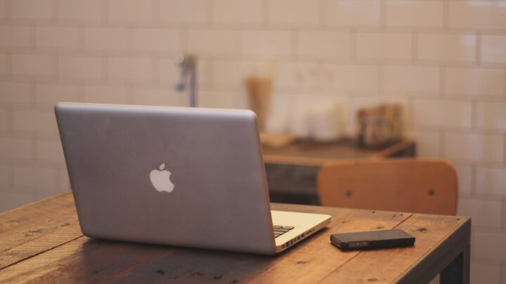 IPhone and laptop arranged on a clean office desk