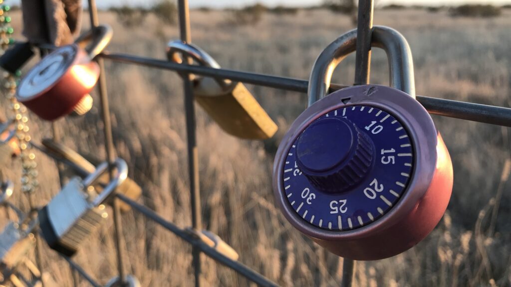 Security lock hanging on a metal fence in the desert
