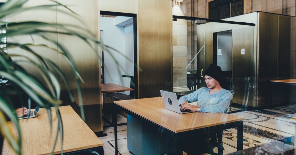 Person working on a laptop in a modern open office
