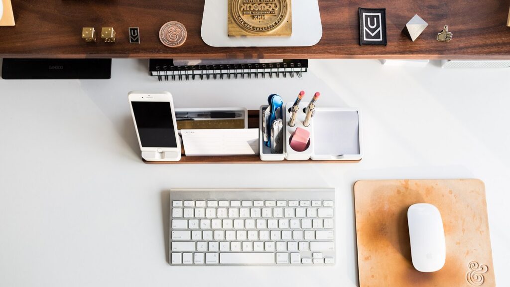 Clean overhead computer workspace with keyboard and phone