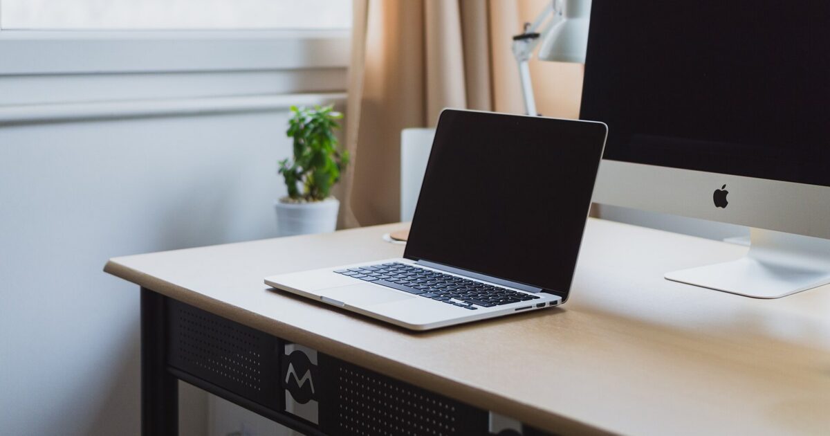 Laptop on a neat modern desk with desktop monitor