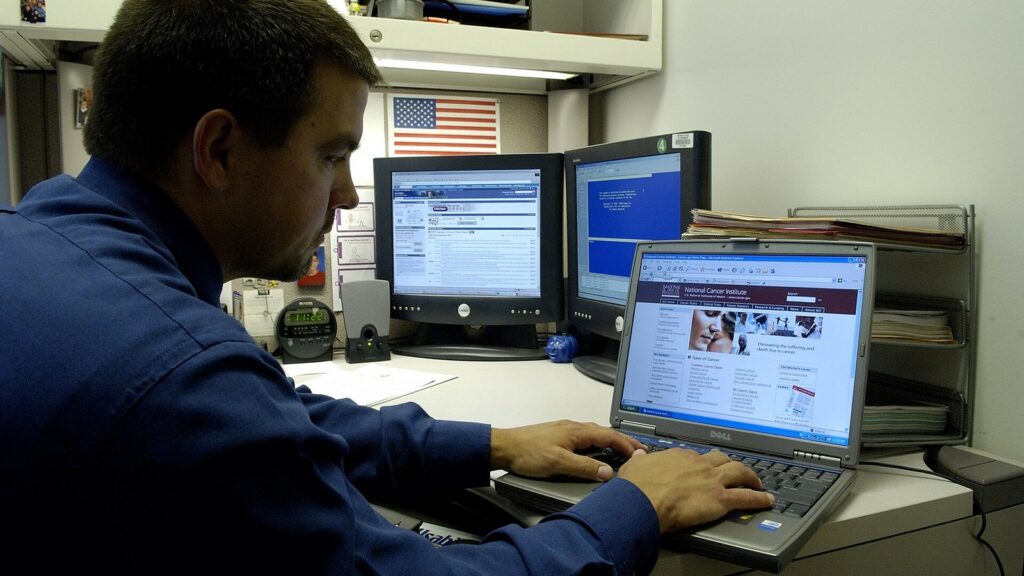 Title man uses laptop description a caucasian male uses his laptop computer at his desk.