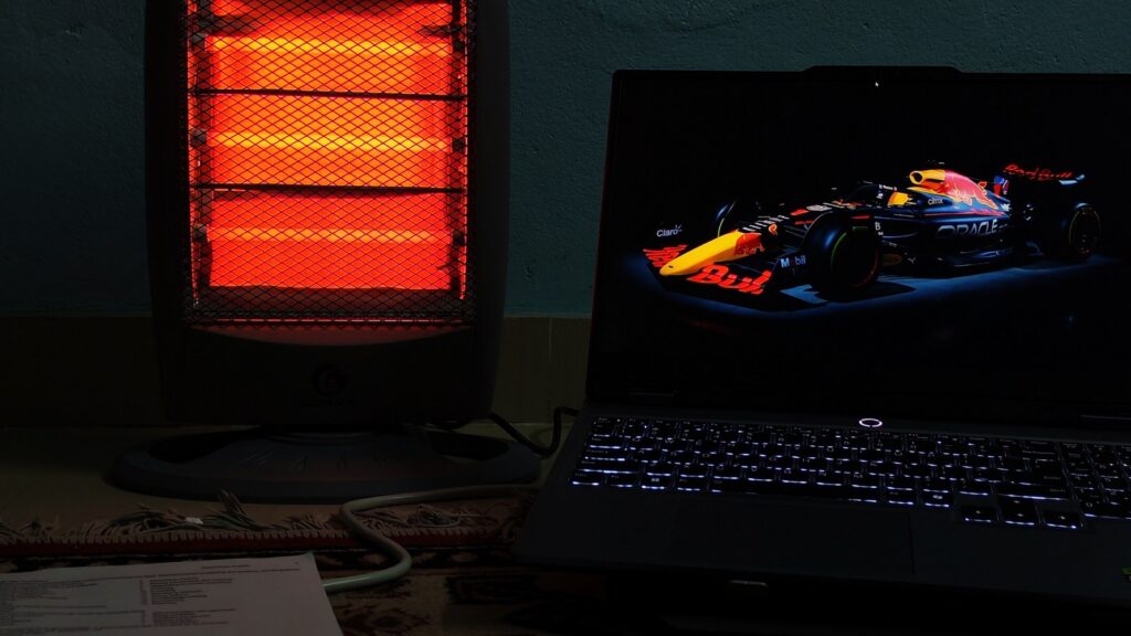 A warm, glowing electric heater is positioned on the left side of the image, casting a reddish light.