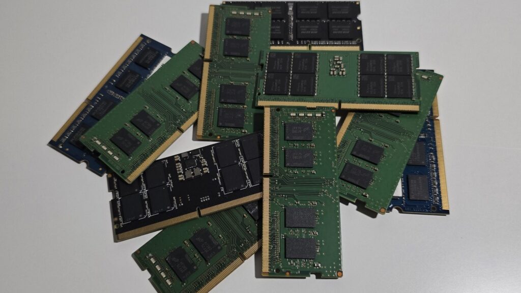 Several laptop RAM sticks on a light surface with black memory chips and gold connectors.