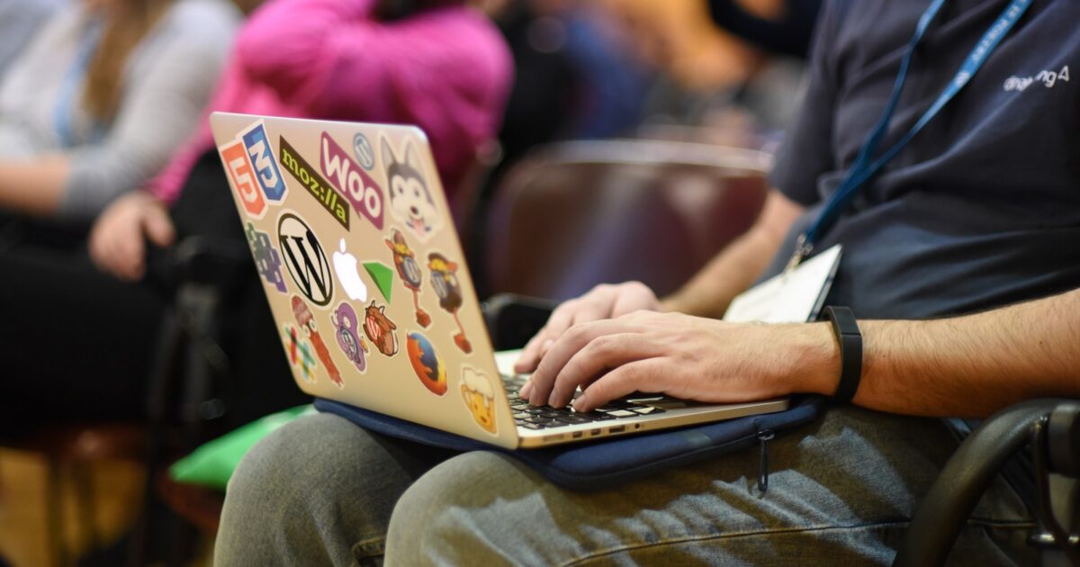 Person taking notes on a laptop at a WordCamp.