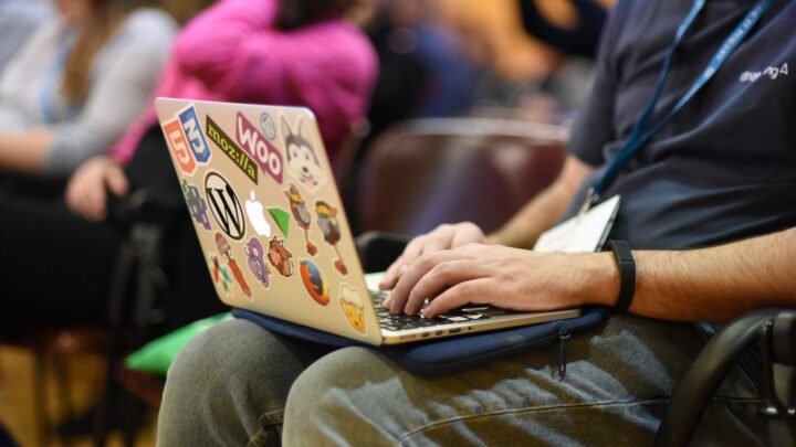 Person taking notes on a laptop at a WordCamp.